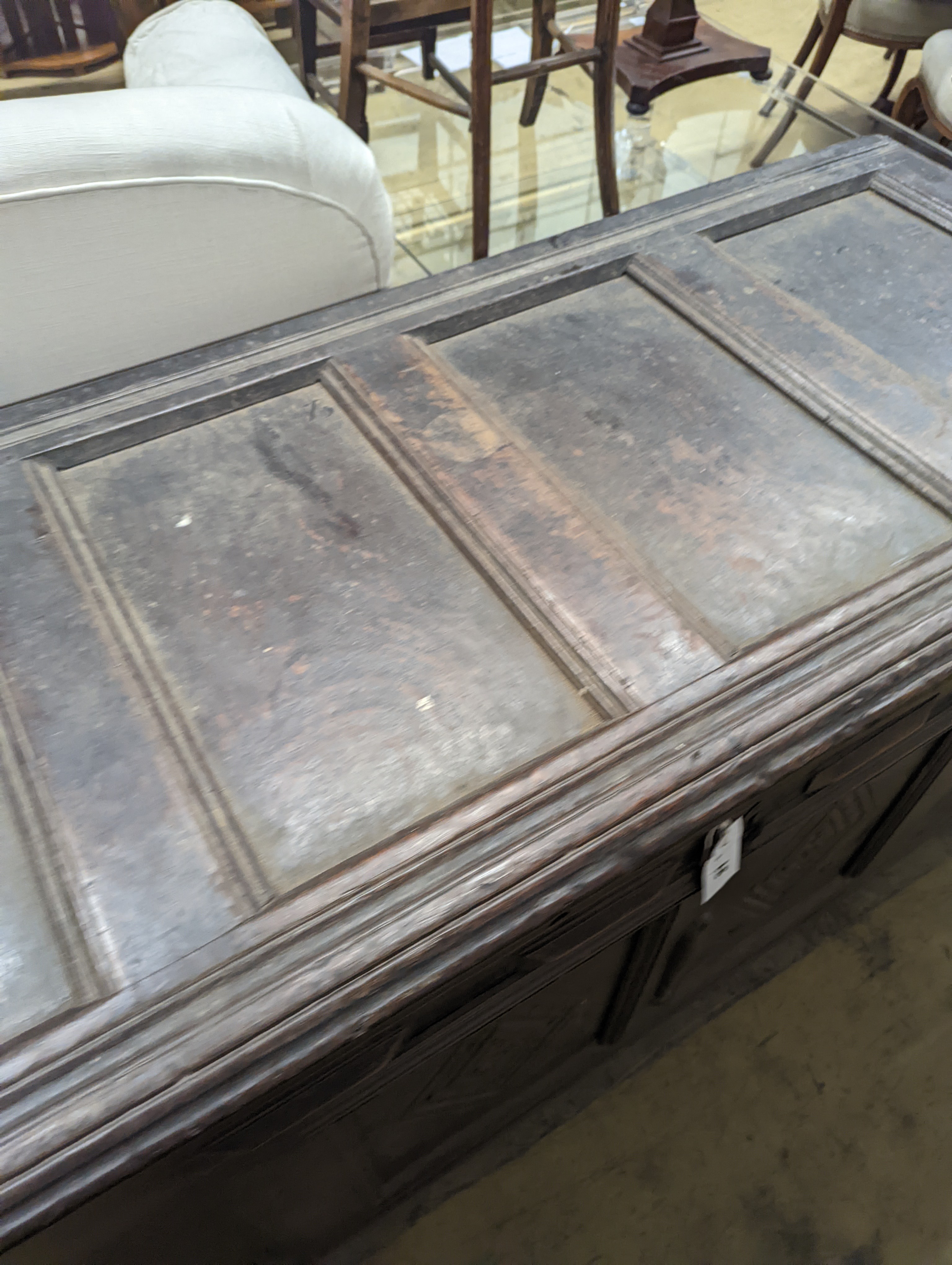 An early 18th century oak coffer, with four panel top and later carved and applied decoration, length 151cm, depth 63cm, height 76cm